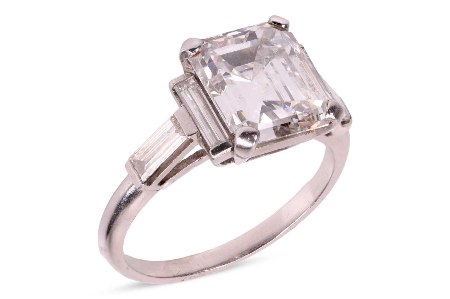 Lot 206 - An emerald-cut diamond ring, featuring an...