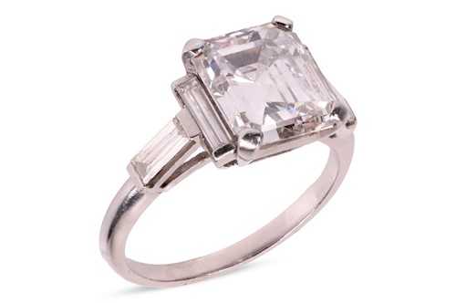 Lot 206 - An emerald-cut diamond ring, featuring an...
