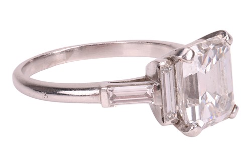 Lot 206 - An emerald-cut diamond ring, featuring an...