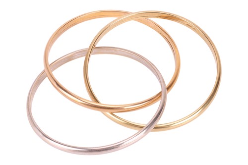 Lot 125 - An 18ct gold tri colour bangle, consisting of...