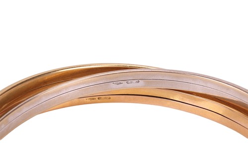 Lot 125 - An 18ct gold tri colour bangle, consisting of...