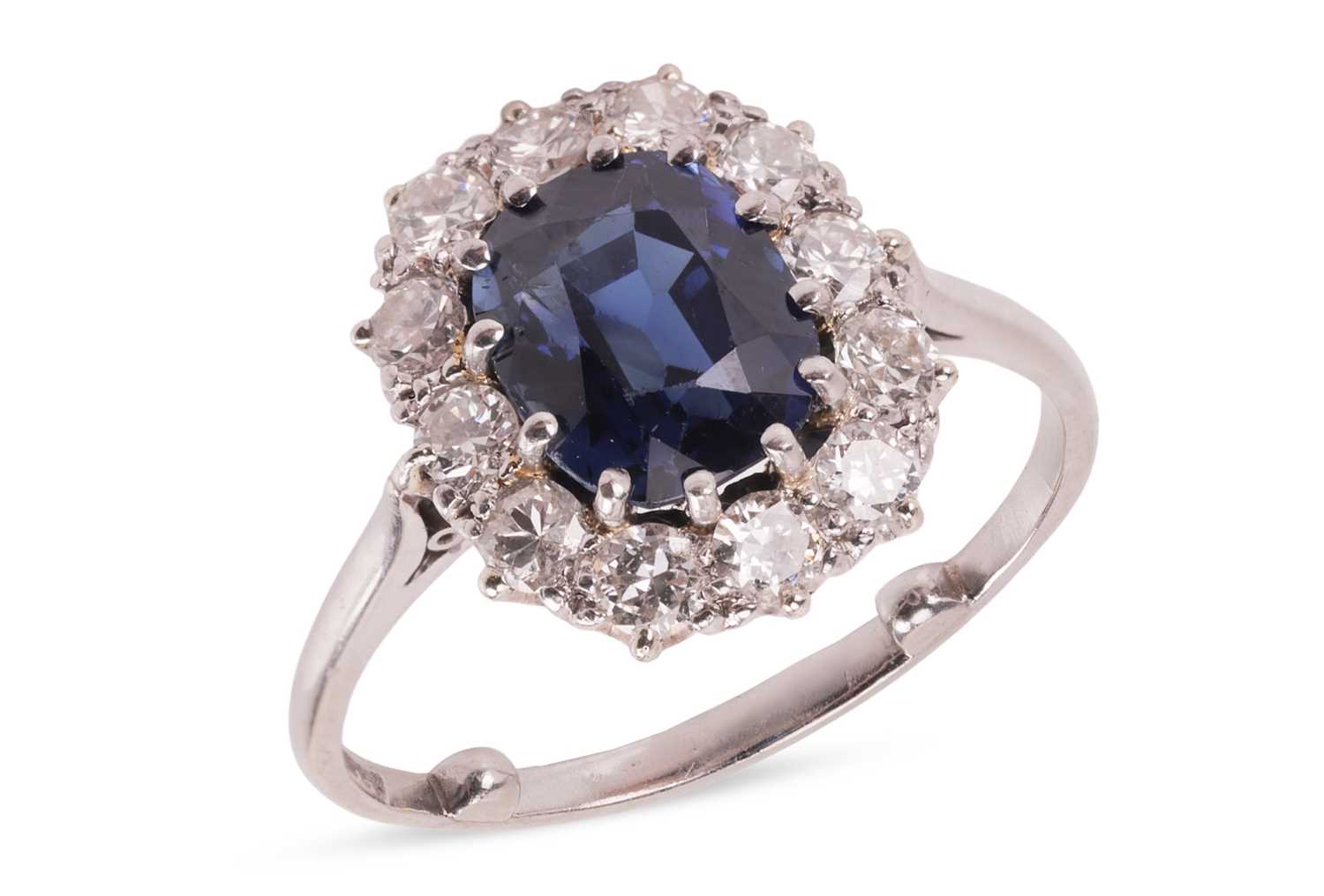 Lot 59 - A sapphire and diamond cluster ring, centred...