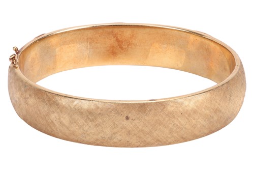 Lot 56 - A hinged bangle of oval form, with...