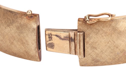 Lot 56 - A hinged bangle of oval form, with...
