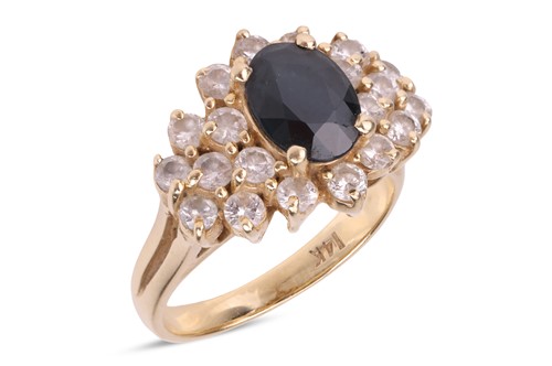 Lot 143 - A sapphire and diamond cluster ring, featuring...