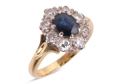 Lot 18 - A sapphire and diamond cluster ring in 18ct...