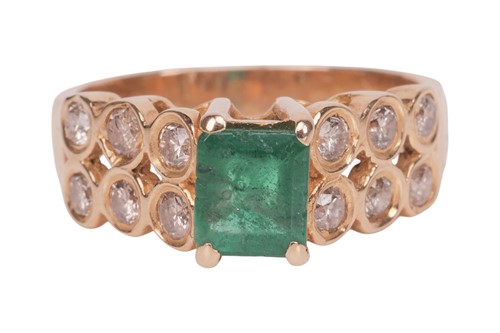 Lot 133 - An emerald and diamond dress ring, featuring a...