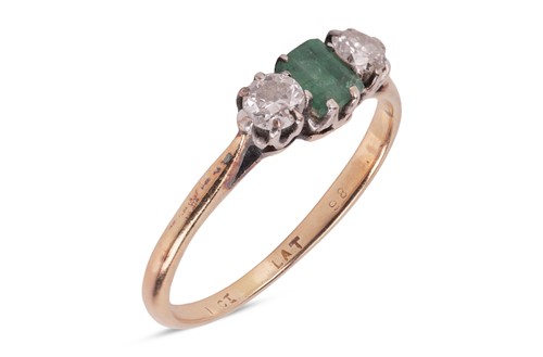Lot 103 - An emerald and diamond trilogy ring, featuring...