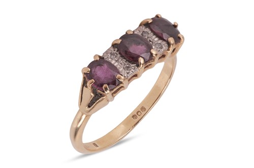 Lot 10 - A ruby and diamond-set ring, featuring three...