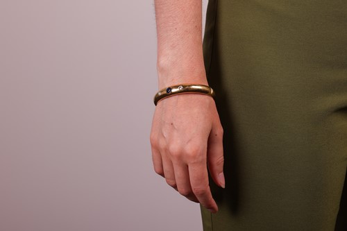 Lot 61 - A sapphire and diamond set hinged bangle, set...