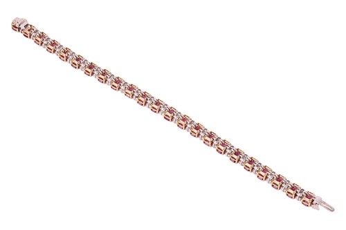 Lot 111 - A ruby and diamond line bracelet, set with...