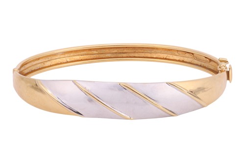 Lot 149 - A hinged bangle, of bi-colour striped design,...