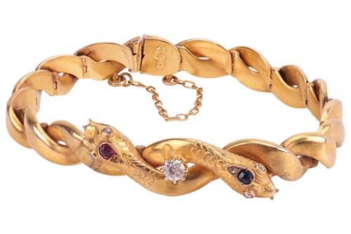 Lot 11 - A gem-set double snake head bracelet, hinged...