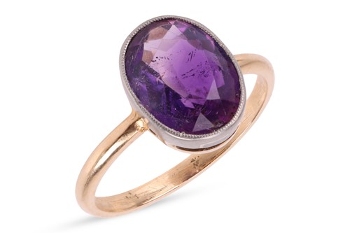 Lot 48 - An amethyst ring, in a bezel setting, with...