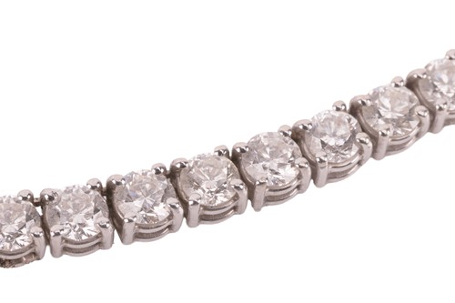 Lot 104 - A diamond riviere necklace, featuring one...