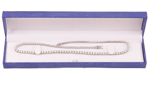 Lot 104 - A diamond riviere necklace, featuring one...