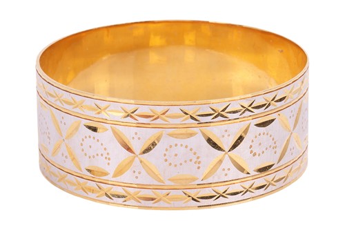 Lot 197 - A bi-colour closed bangle, the outside...