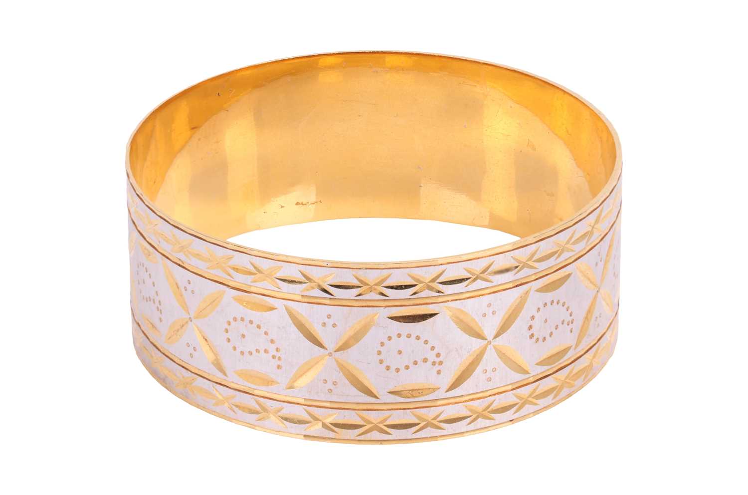 Lot 197 - A bi-colour closed bangle, the outside...