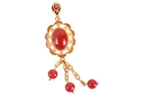 Lot 83 - A carnelian pendant, the central oval cabochon...
