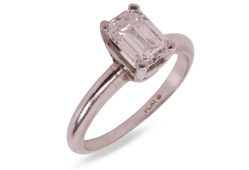 Lot An emerald-cut diamond solitaire ring, the...