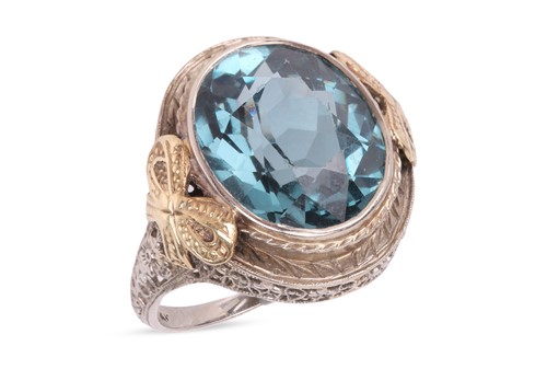 Lot 18 - A dress ring, set with an oval-cut blue...