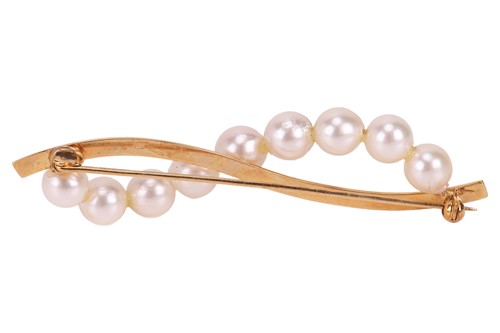 Lot A pearl set brooch, set with a scrolling row...