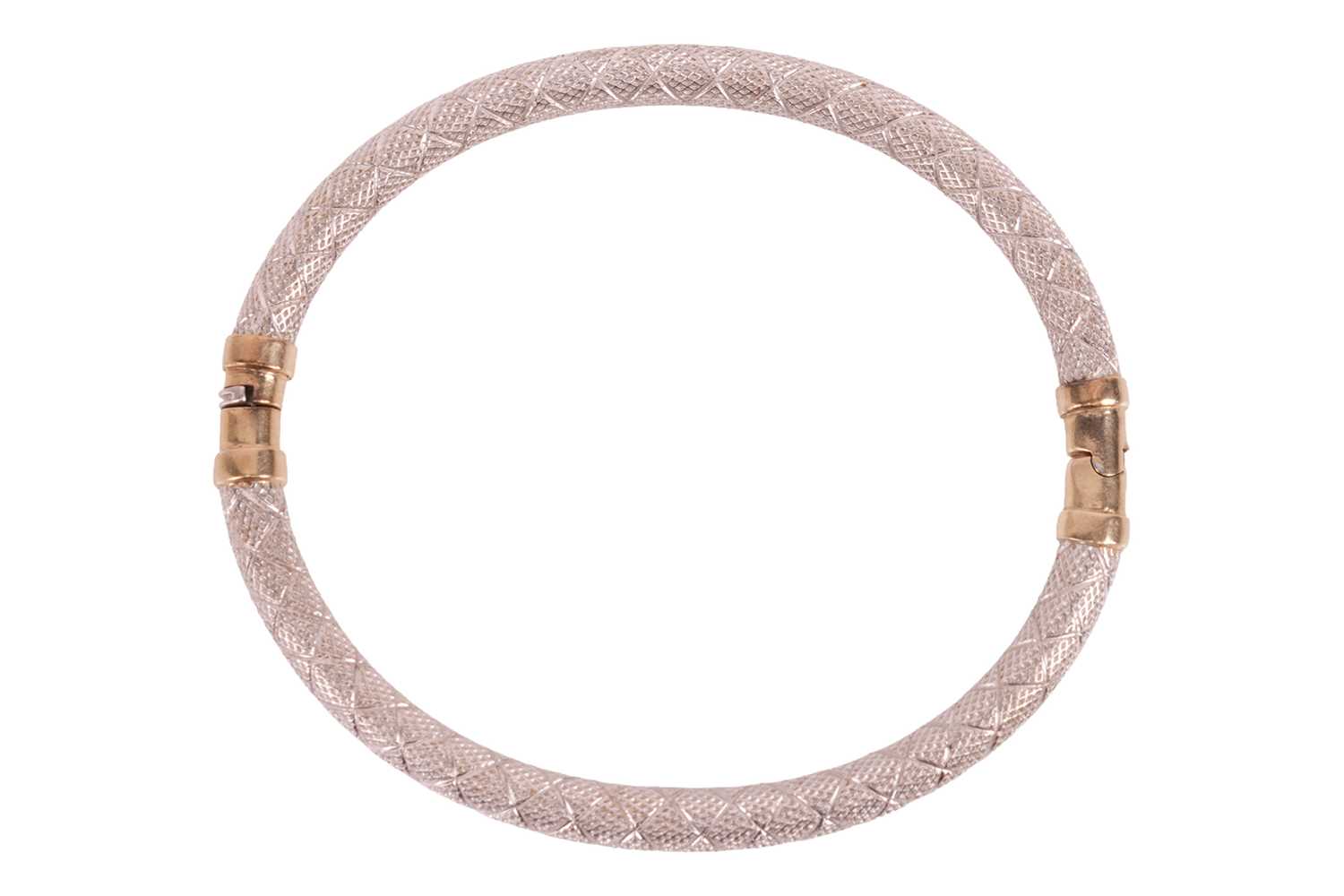 Lot A two-tone gold bangle, the engraved bangle in...