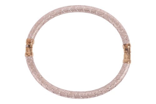Lot A two-tone gold bangle, the engraved bangle in...