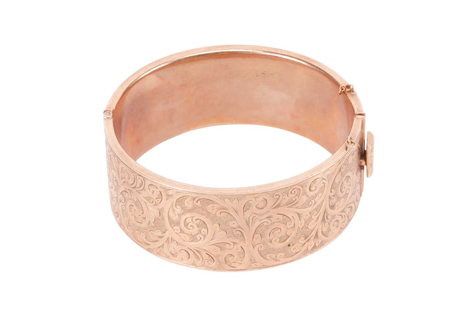 Lot A 9 carat gold bangle, the hinged bangle with...