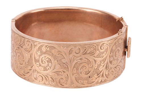 Lot A 9 carat gold bangle, the hinged bangle with...
