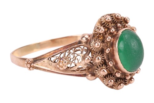 Lot A green paste ring, centrally-set with an oval...